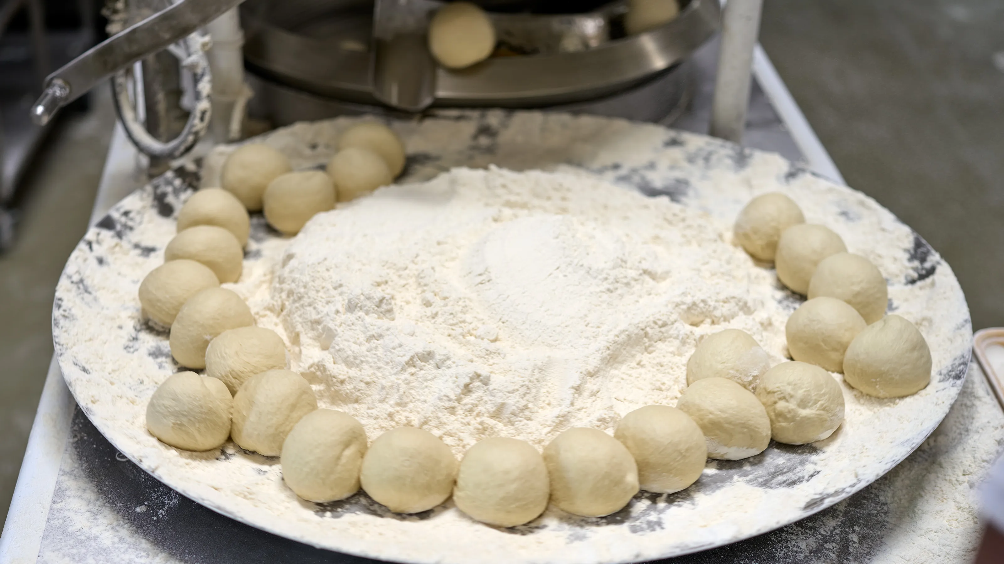 Dough rounds set around a plate of flour